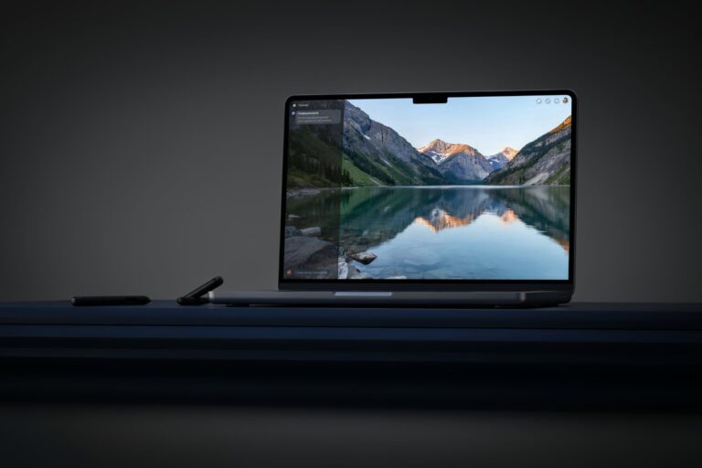 Laptop mit Bearbeitung eines Bergsee-Fotos auf dunklem Schreibtisch